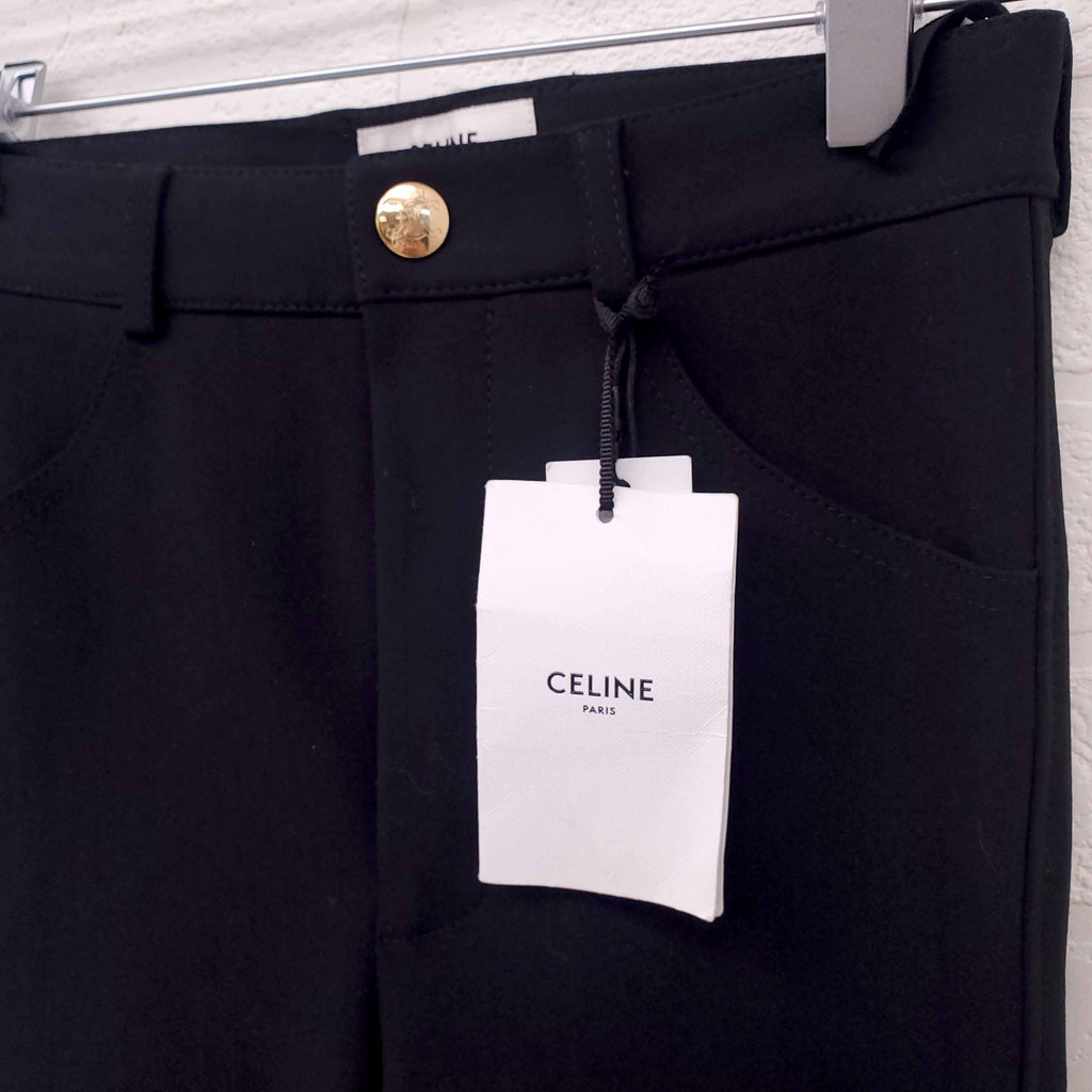 Black pants with a Celine tag on a white background