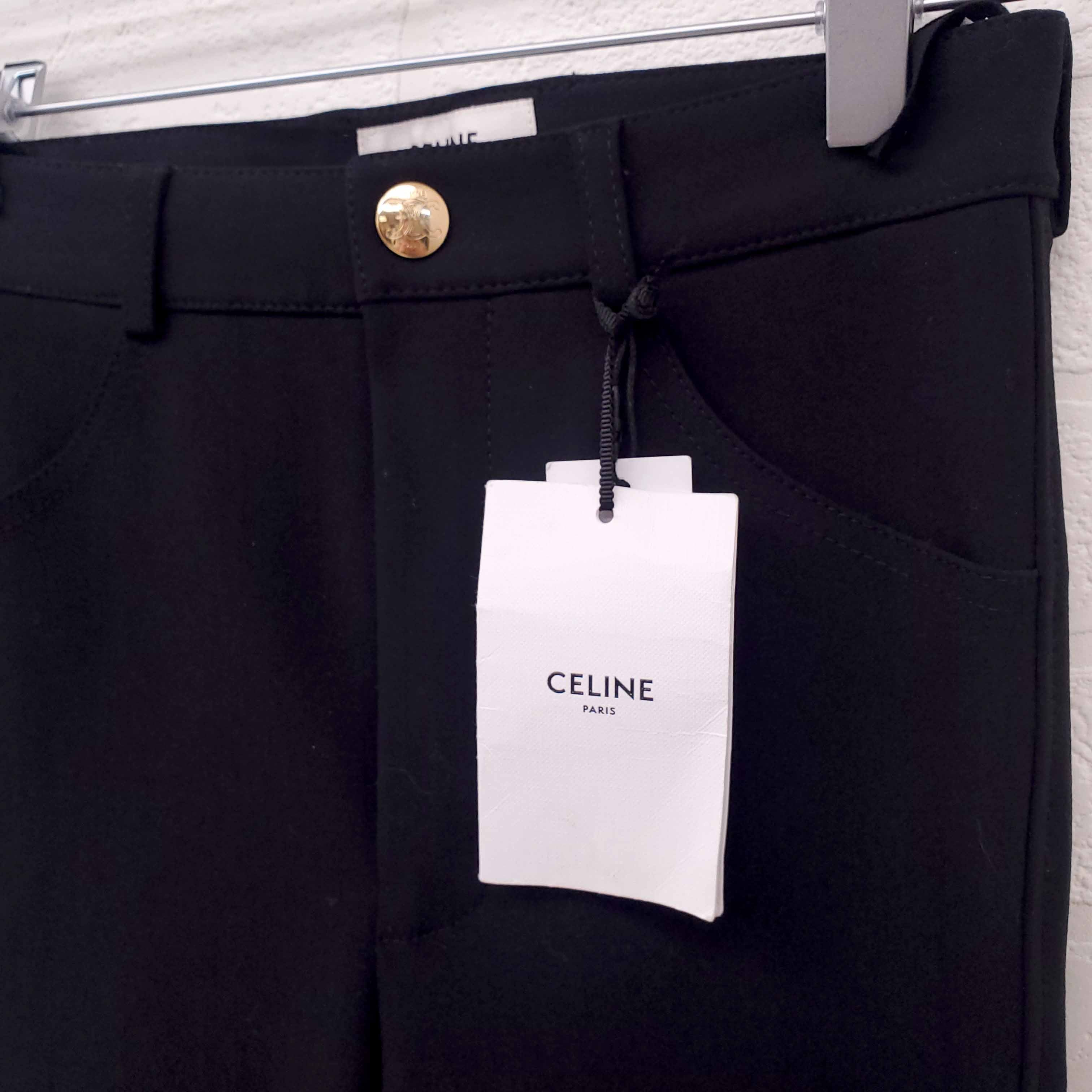 Black pants with a Celine tag on a white background