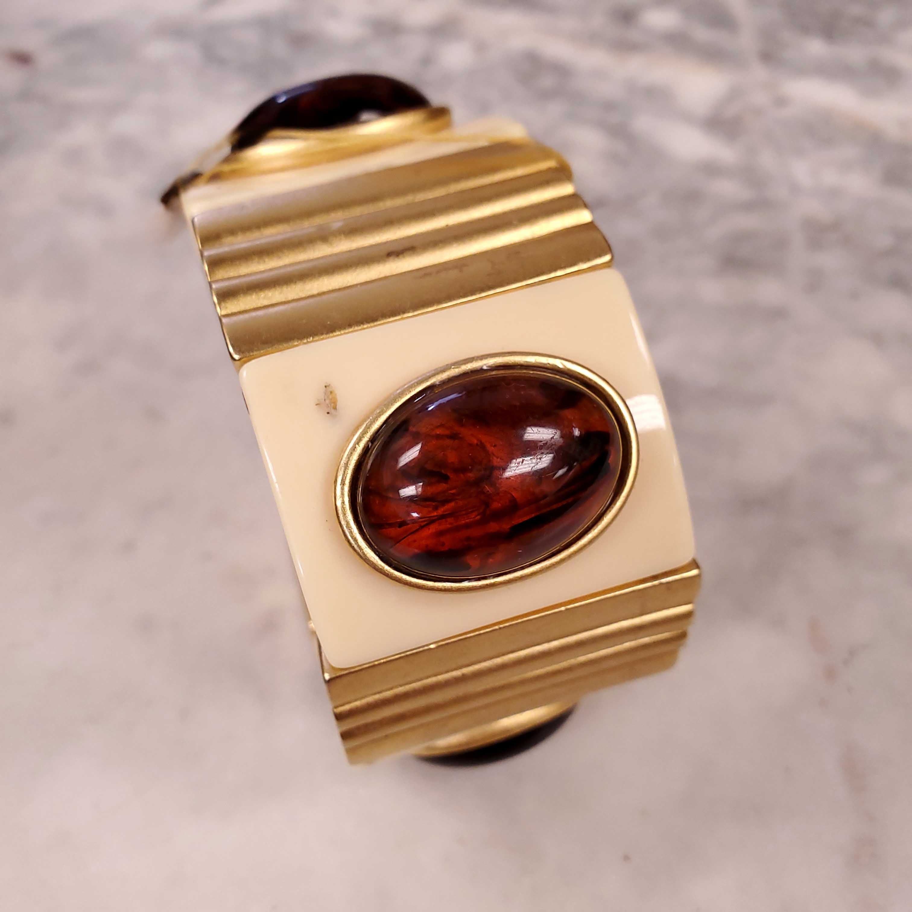 YVES SAINT LAURENT EXPANSION BRACELET WITH AMBER CABOCHONS SET IN CREAM AND GOLD-COLOURED PLASTIC